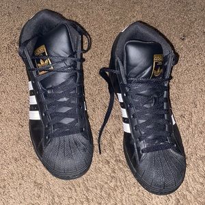 Black shell toe high-top Adidas